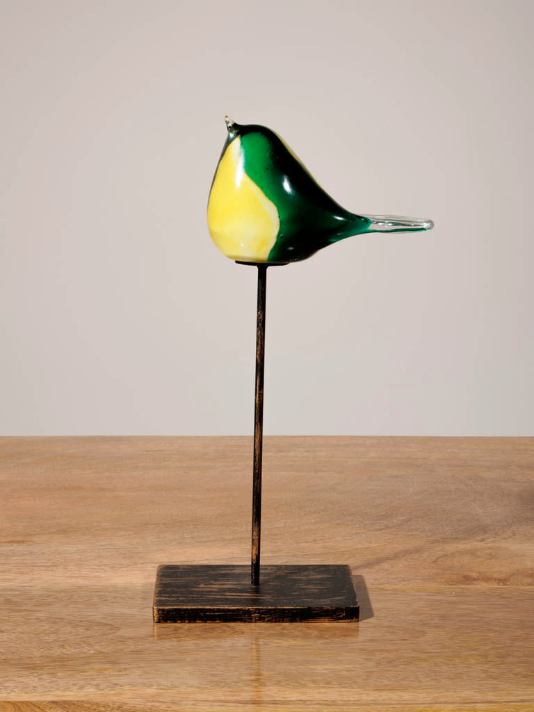 Green and yellow glass bird on stand